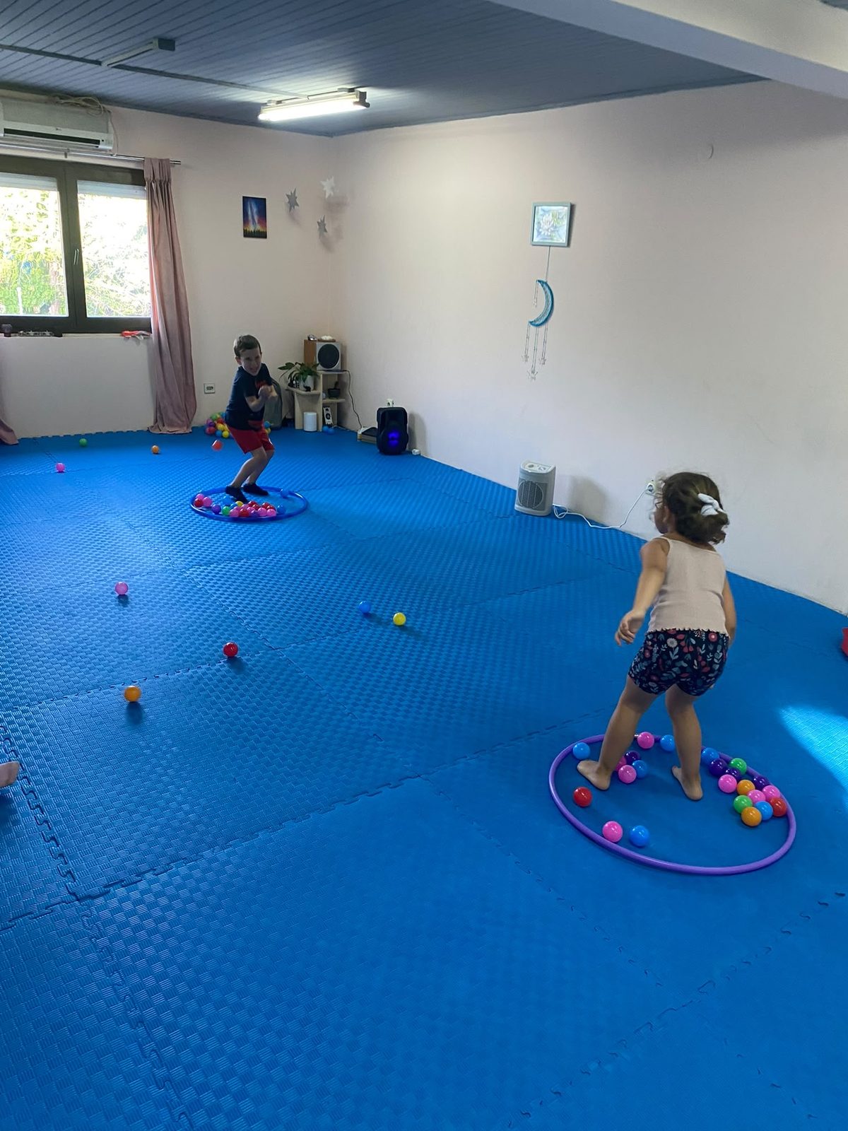 Deca se igraju sa loptama u obručima u sali Sportikada